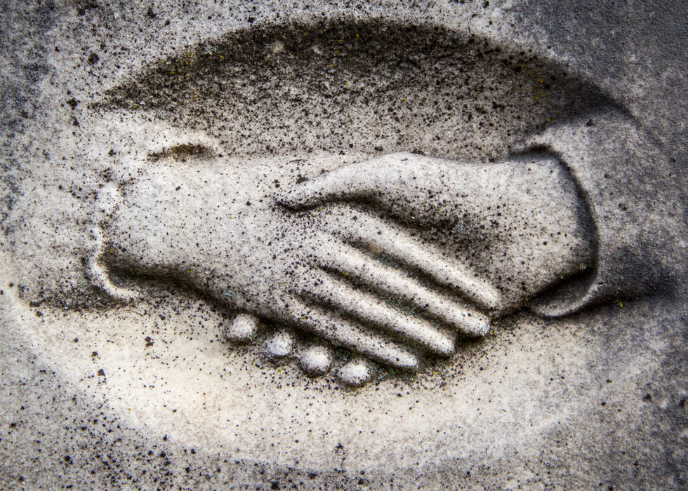 Clasped hands on stone grave stone