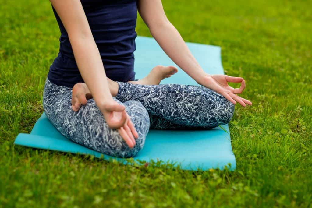 woman practicing yoga on the lawn