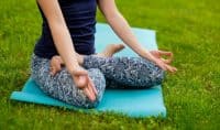 woman practicing yoga on the lawn