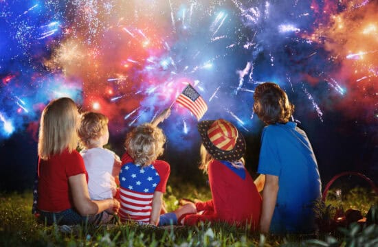 American family celebrating Independence Day. Picnic and fireworks on 4th of July in America. USA flag. Parents and kids celebrate US holiday. Children watching firework.